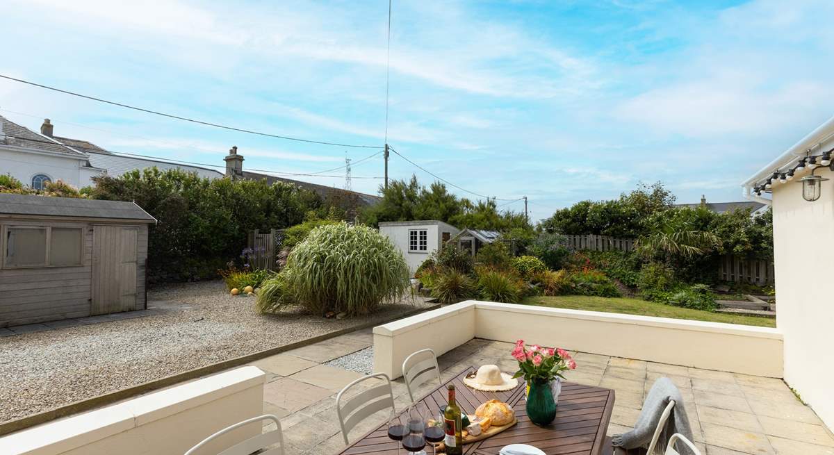 The patio is a sheltered spot, perfect for an al fresco evening. The external lighting twinkles gently creating serene ambience.