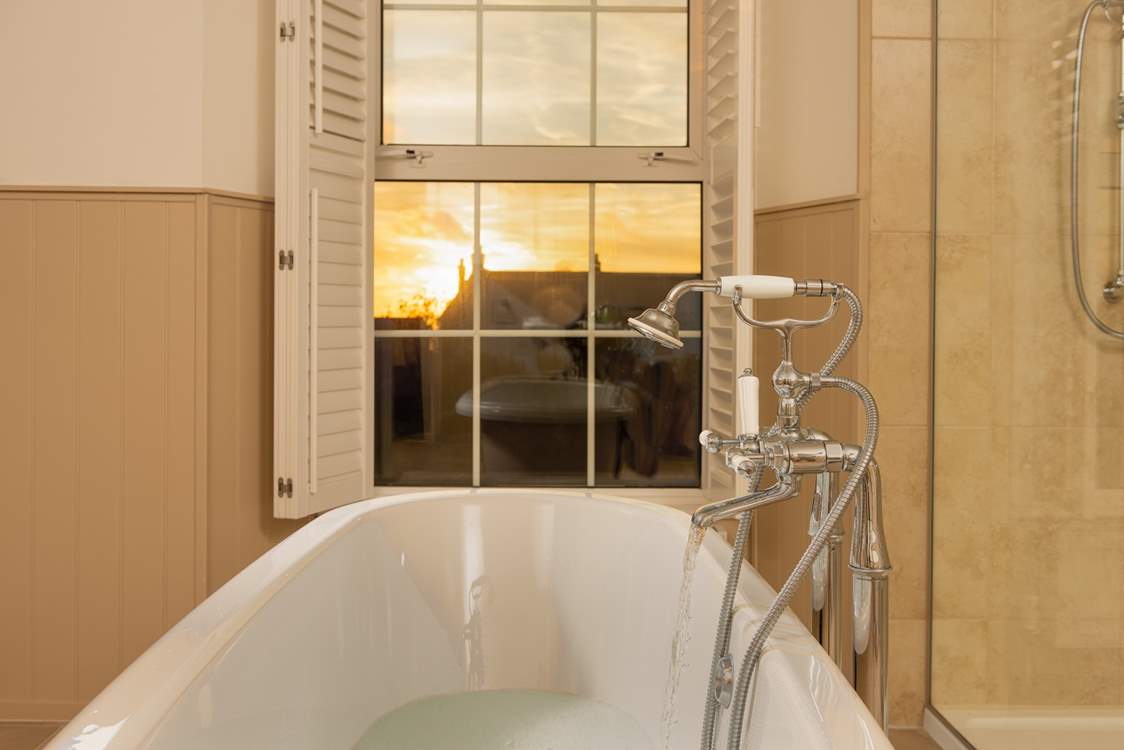 Pour yourself a glass of something ice cold and watch the sun set from the comfort of the roll-top bath.