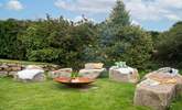 The fire-pit perfectly complements the setting, with large granite boulders as the seating. - Thumbnail Image