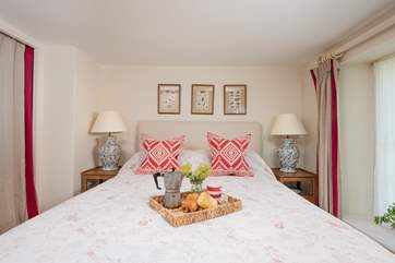 Snuggle up under the covers in the king-size bed.