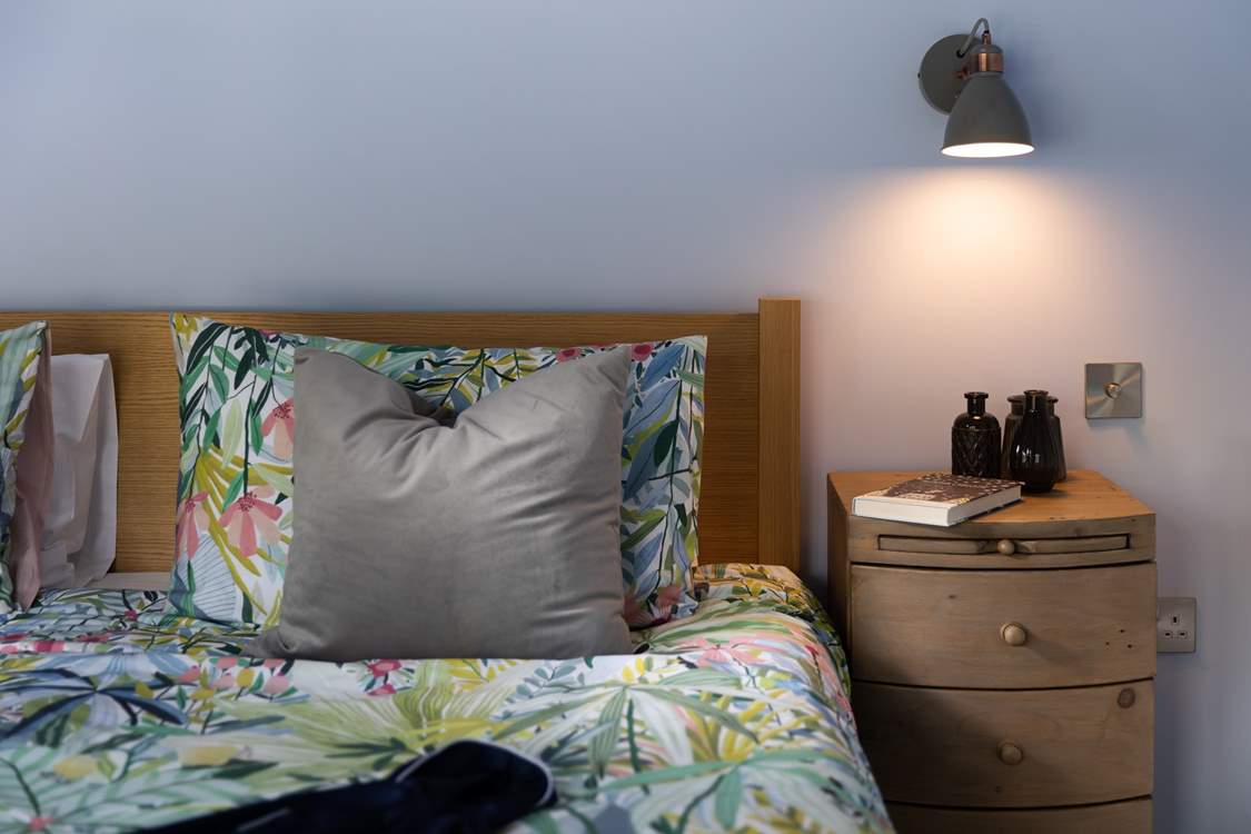 The beautifully recycled bedside cabinets have a nifty little pull out table.