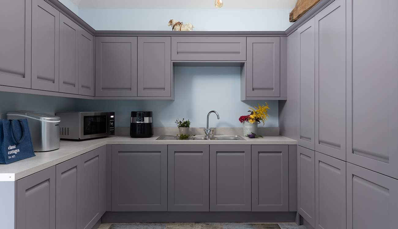 The utility-room has a washing machine, air fryer, and very useful ice making machine. Kick off your boots and hang up your coats in here too. 