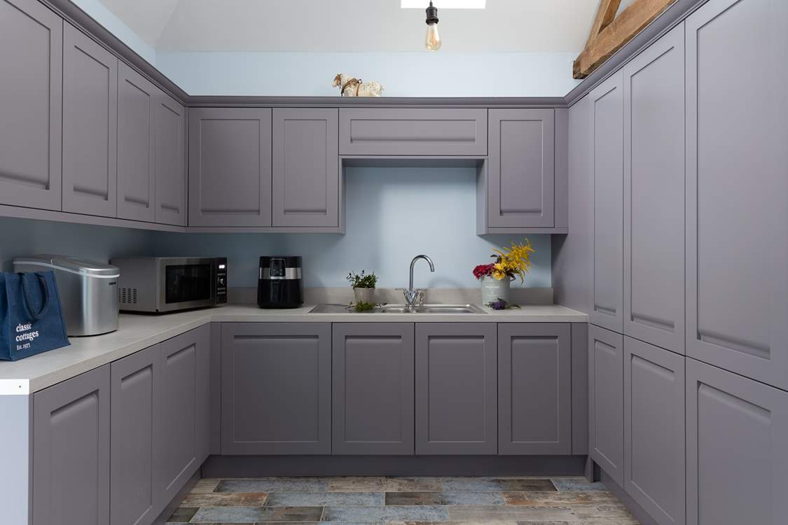 The utility-room has a washing machine, air fryer, and very useful ice making machine. Kick off your boots and hang up your coats in here too.