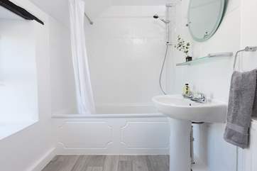 The sparkling family bathroom has a heated towel rail.