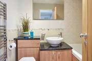 Modern family bathroom with a hand shower attachment is situated on the ground floor next door to the children's room.