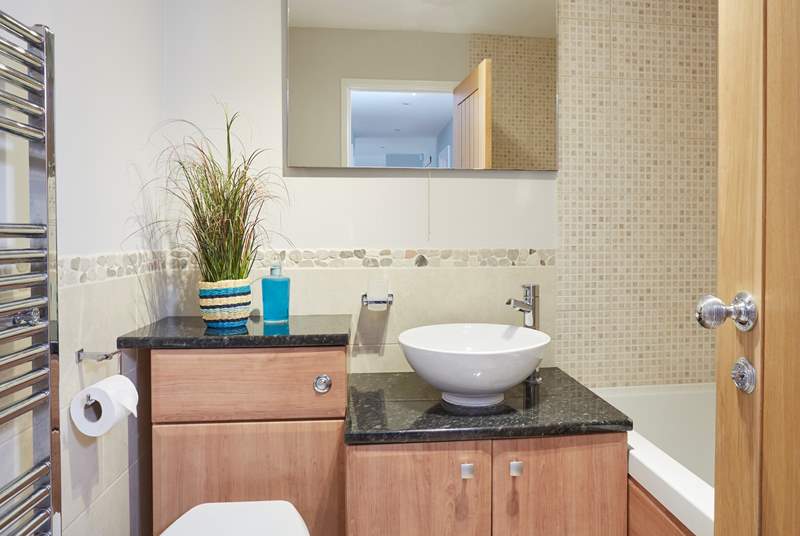 Modern family bathroom with a hand held shower is situated on the ground floor next door to the kid's room.
