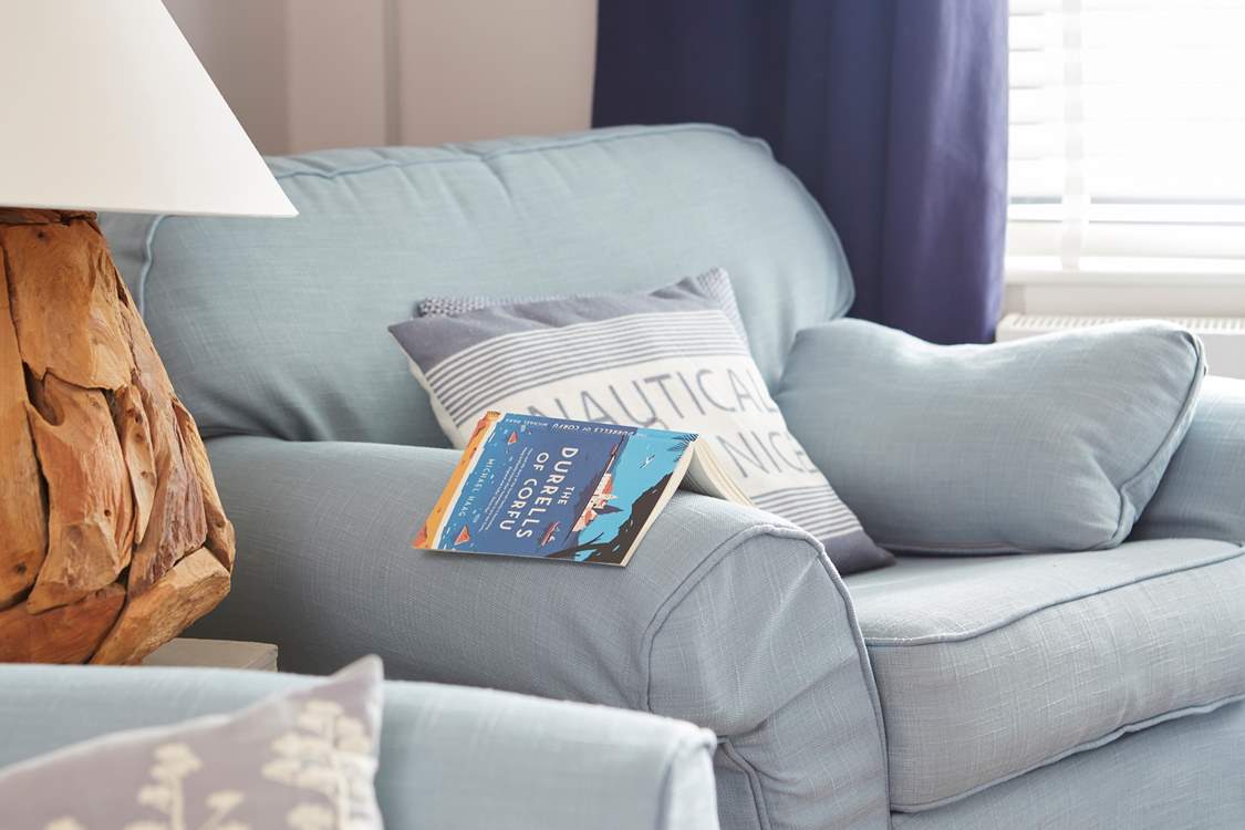 A good read in the sitting-room. The bookshelf has a wealth of novels.