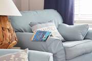 A good read in the sitting-room. The bookshelf has a wealth of novels.