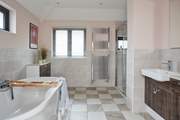 The en suite bathroom in the main suite has both a free-standing bath and shower, and double wash-basins.