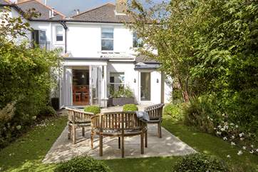 The charming garden and terrace areas leading into the house at the rear.