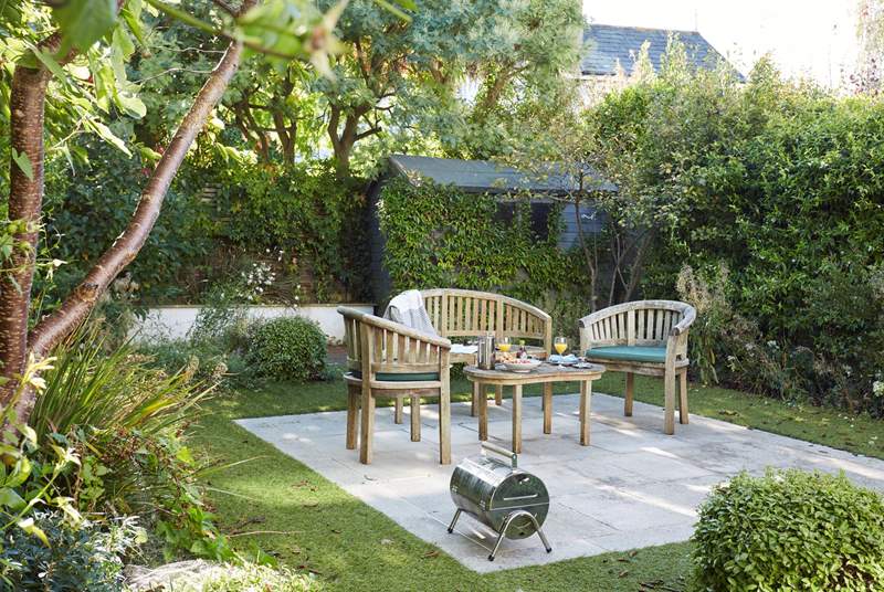 The charming  garden area with seating and a small coffee table perfect for morning coffee.