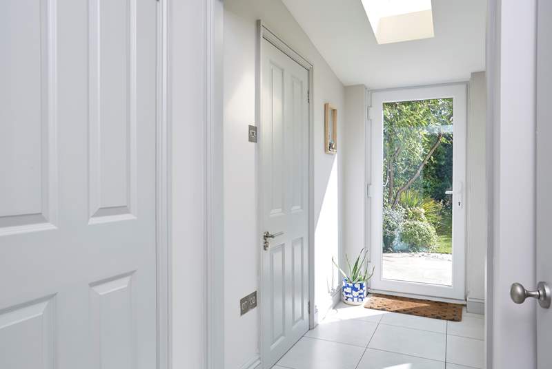 The hallway off the kitchen with the cloakroom on the left leads from the utility into the enclosed garden.