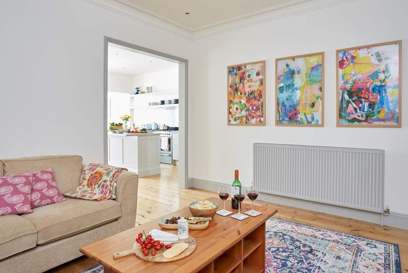 The large snug with comfortable corner sofa and bright abstract art leads into the kitchen. In the cooler months light up the wood-burner for that added slice of luxury.