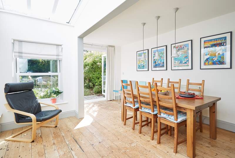 A dining-table for six and a few extra chairs for guests, with patio door access to the rear garden and the gate to the parking space.
