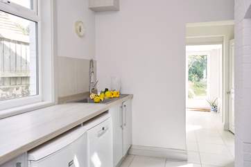 The utility-room with washing machine, tumble-drier, dishwasher and wash-basin also has plenty of storage space.
