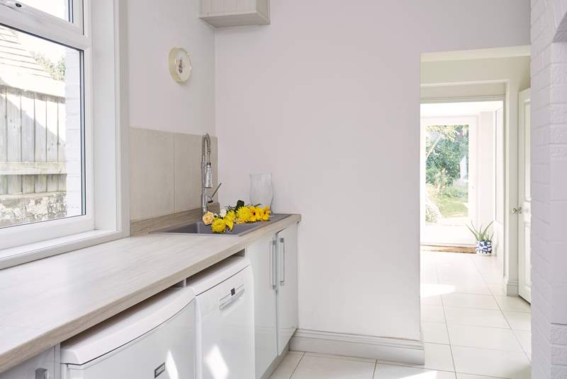 The utility-room with washing machine, tumble-drier, dishwasher and wash-basin also has plenty of storage space.