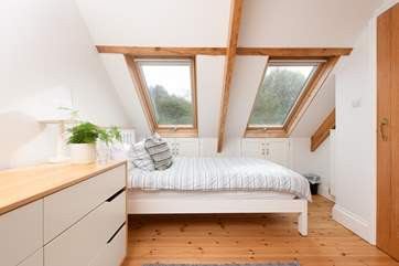 The bedroom is full of natural light due to the Velux windows.