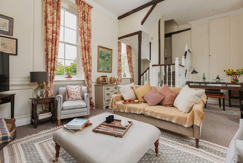 The elegant sitting-room with wood panelling and exposed beams is the perfect place to unwind.