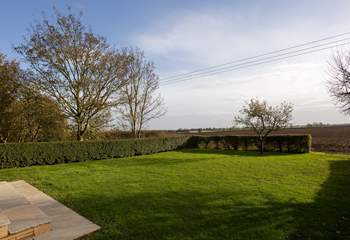 The large garden opens onto the fields beyond.