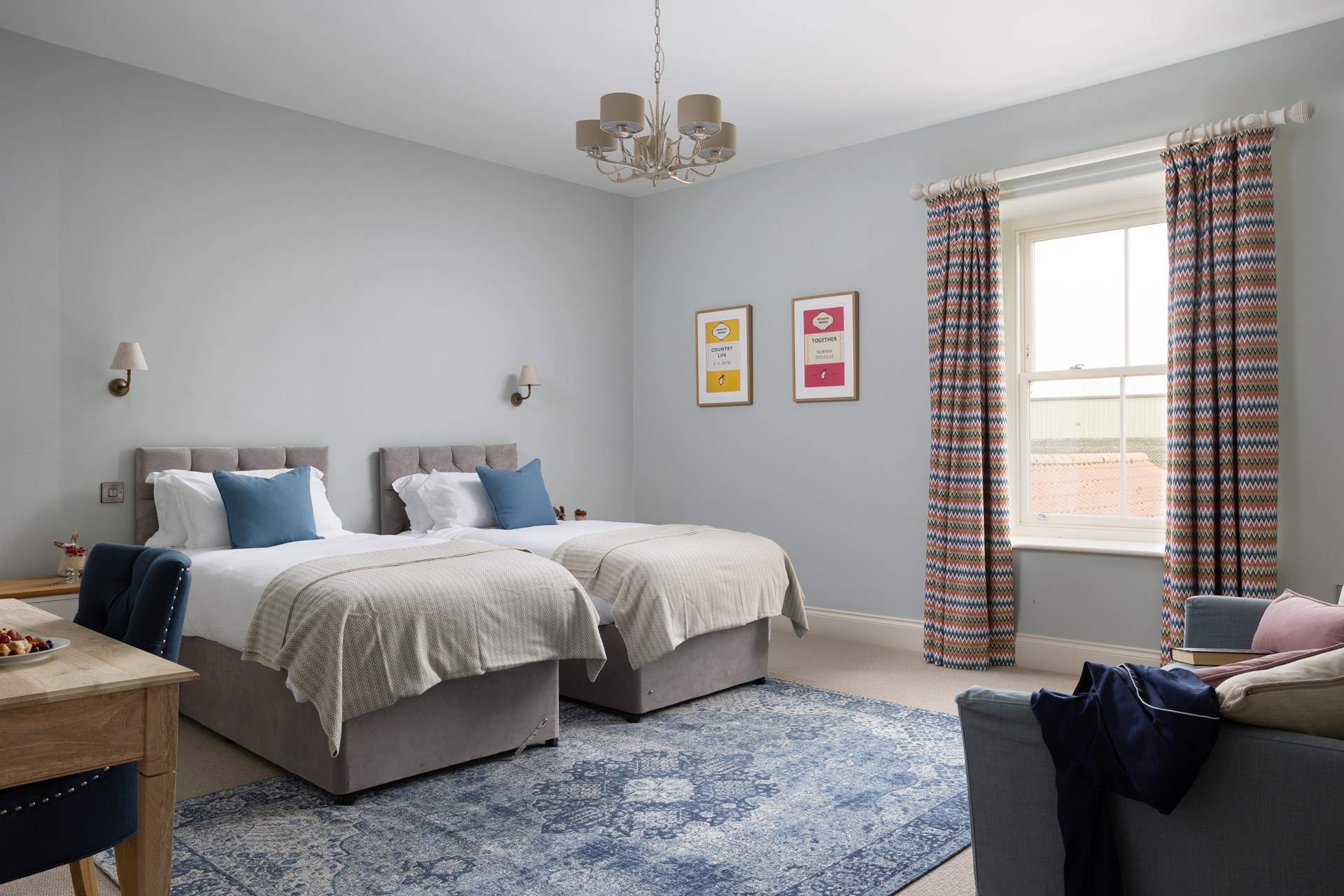 A large twin room with a sofa to relax on.