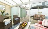 The sun-room offers additional seating and leads out to the patio. - Thumbnail Image