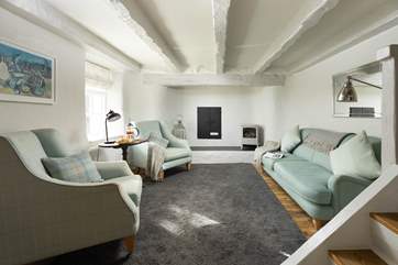 Four steps lead down into the charming sitting-room, snuggle up in front of the wood-burner effect electric stove.