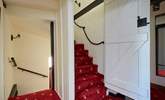 Through the latch door, the steps leading up to the top floor with rope hand rail. - Thumbnail Image