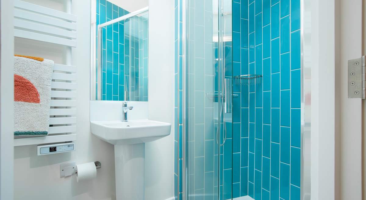 The en suite shower-room with vibrant blue tiles and a cleverly fitted skylight.