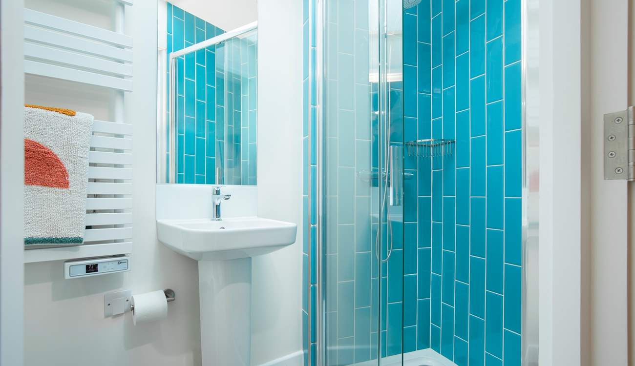 The en suite shower-room with vibrant blue tiles and a cleverly fitted skylight.