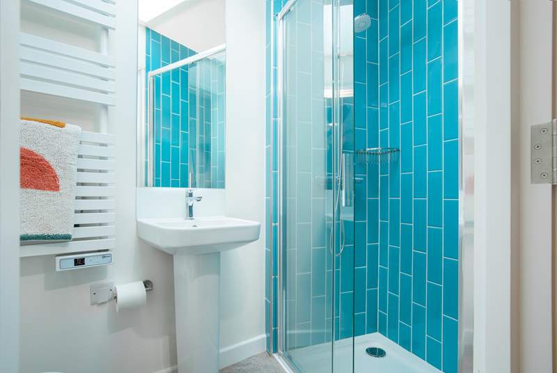 The en suite shower-room with vibrant blue tiles and a cleverly fitted skylight.