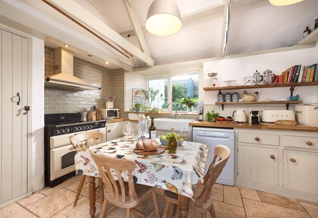 The light and spacious kitchen is designed in a classic farmhouse style.