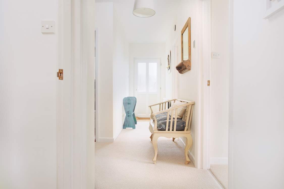 The lower ground floor hallway has a door to the side of the house and access to the lower terraces.