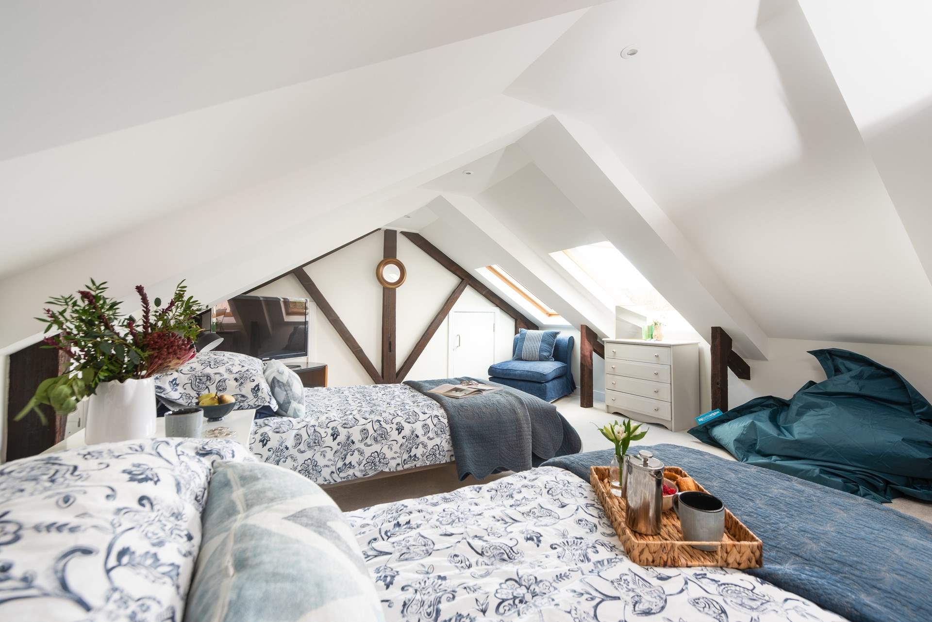 The bedroom is full of character set under the eaves.