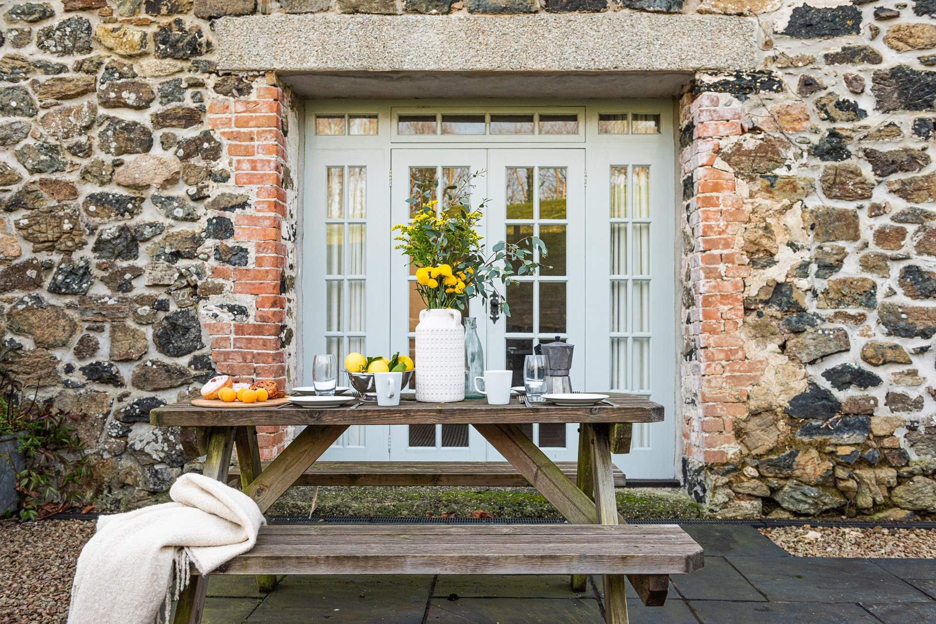 The picnic table is just off the sitting-room and is a great spot to relax. I love the gorgeous granite lintels.