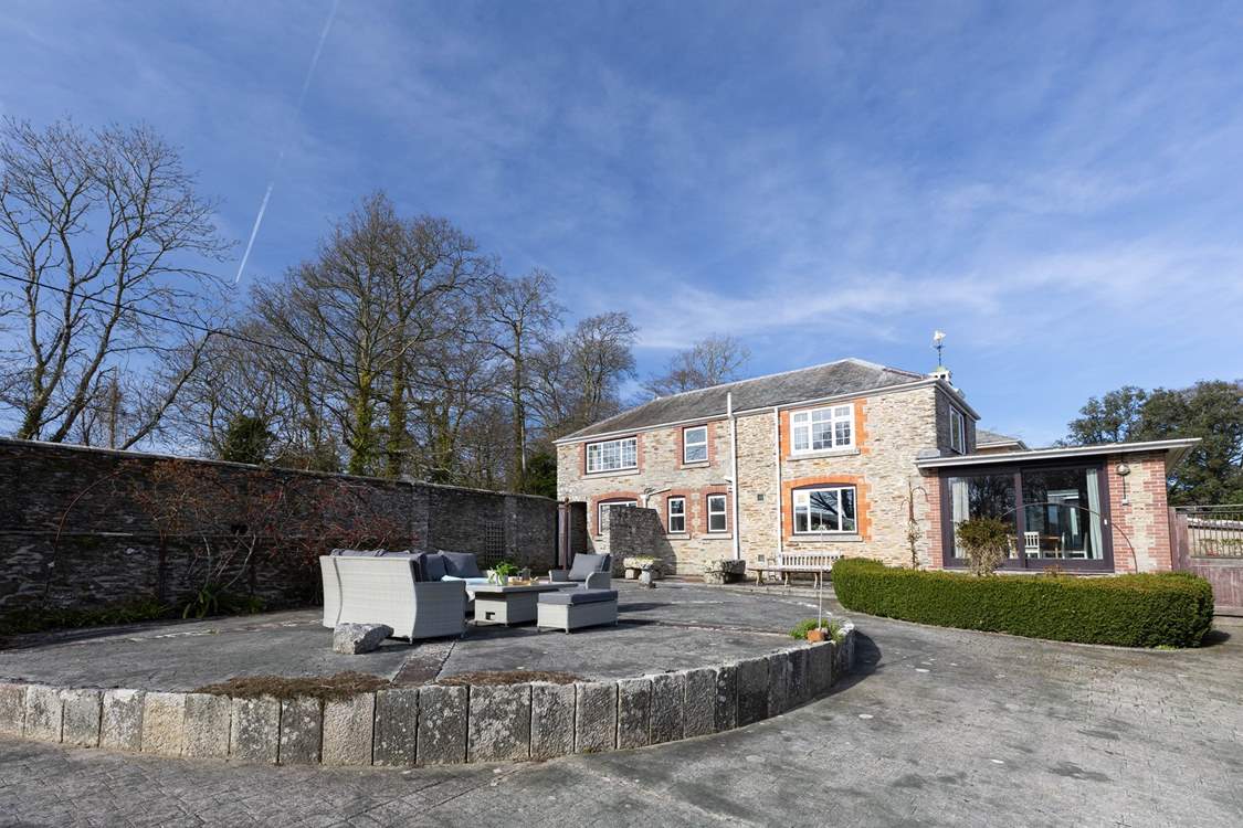 The large terrace to the side of the house catches the afternoon sun.