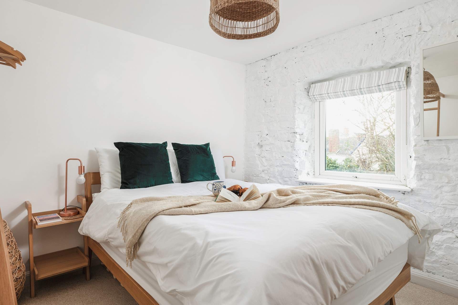 The second bedroom offers rustic charm with views out to the back garden. 