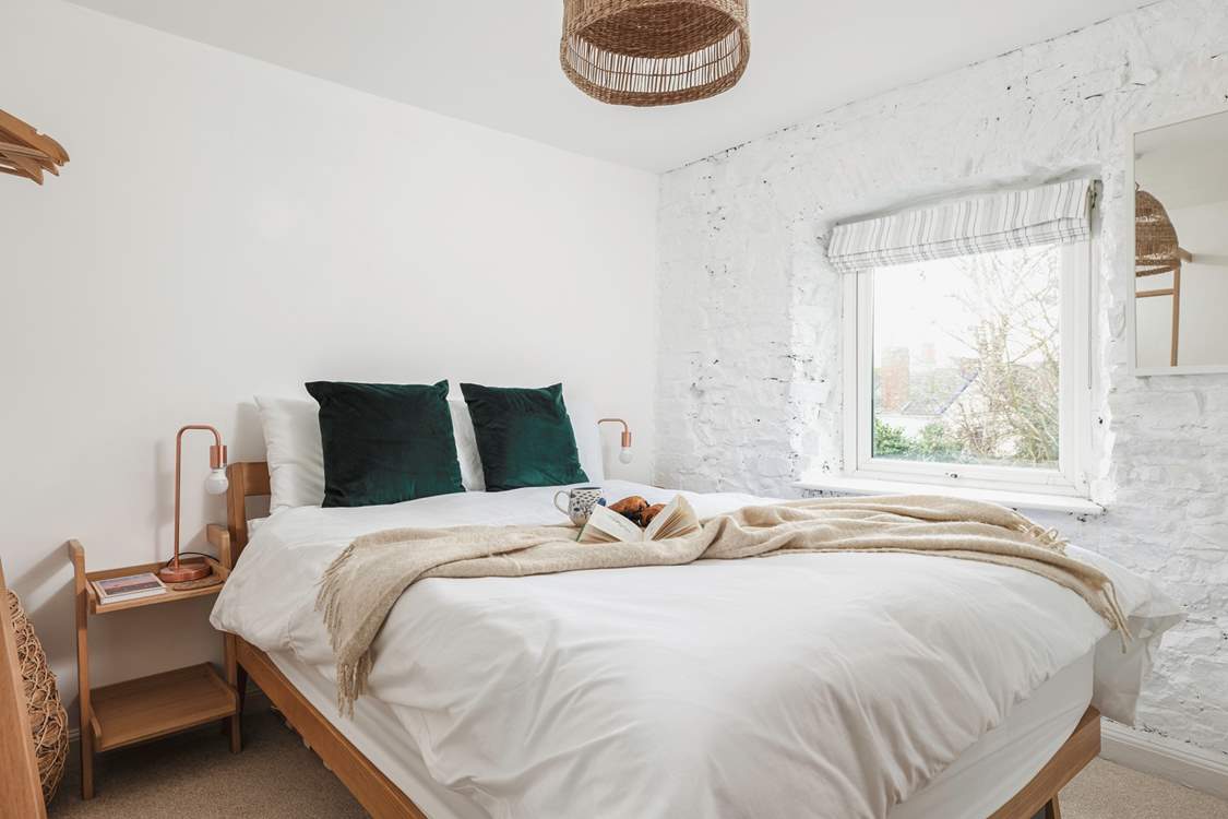 The second bedroom offers rustic charm with views out to the back garden.