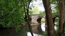 The approach to Leat Mill Cottage is over the small bridge and down beside the river.
