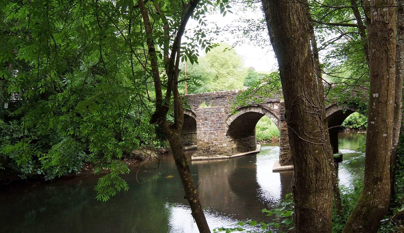 The approach to Leat Mill Cottage is over the small bridge and down beside the river.