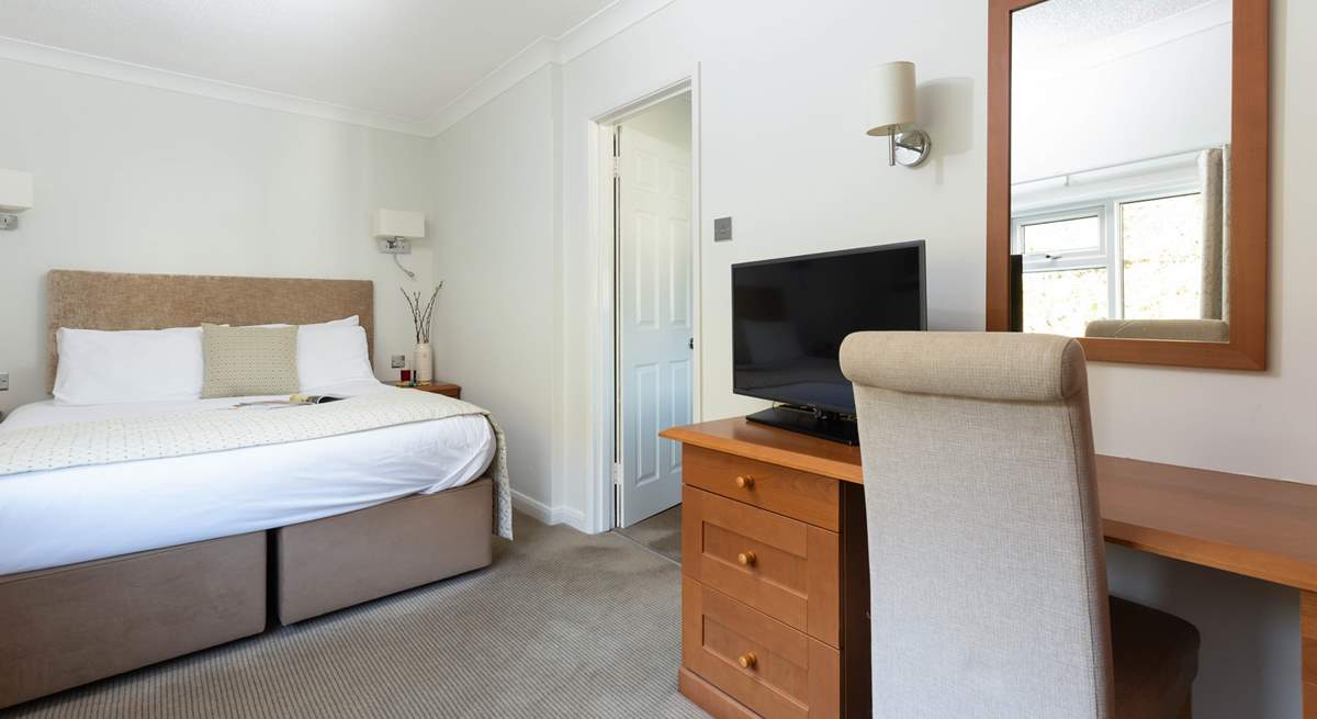 This spacious bedroom offers a comfy bed and a TV should you need to retreat. 