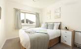 The bedroom is light and bright with calming muted tones. - Thumbnail Image