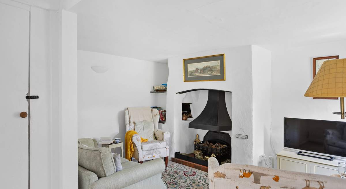 The cute sitting-room has an ornamental fireplace and Smart TV, perfect for a film night after enjoying a coastal walk.