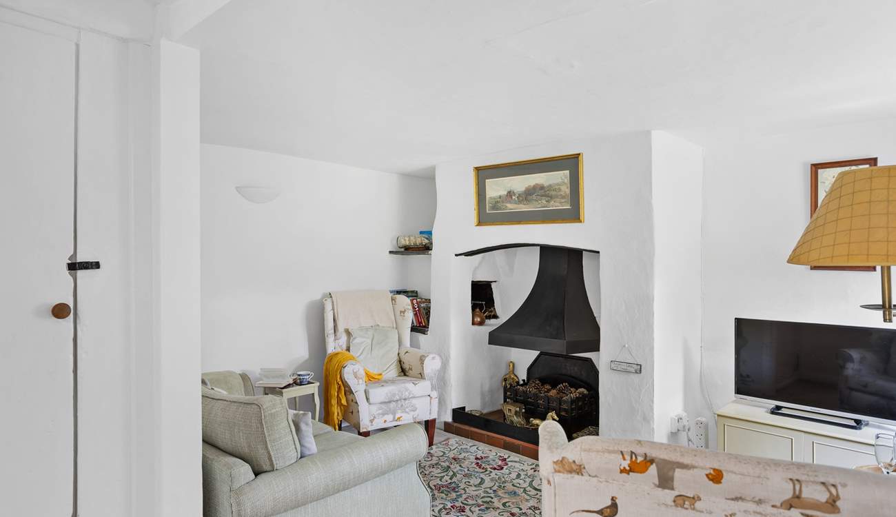 The cute sitting-room has an ornamental fireplace and Smart TV, perfect for a film night after enjoying a coastal walk.