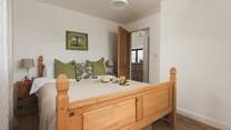 This bedroom is dual aspect with a king-size bed and TV.