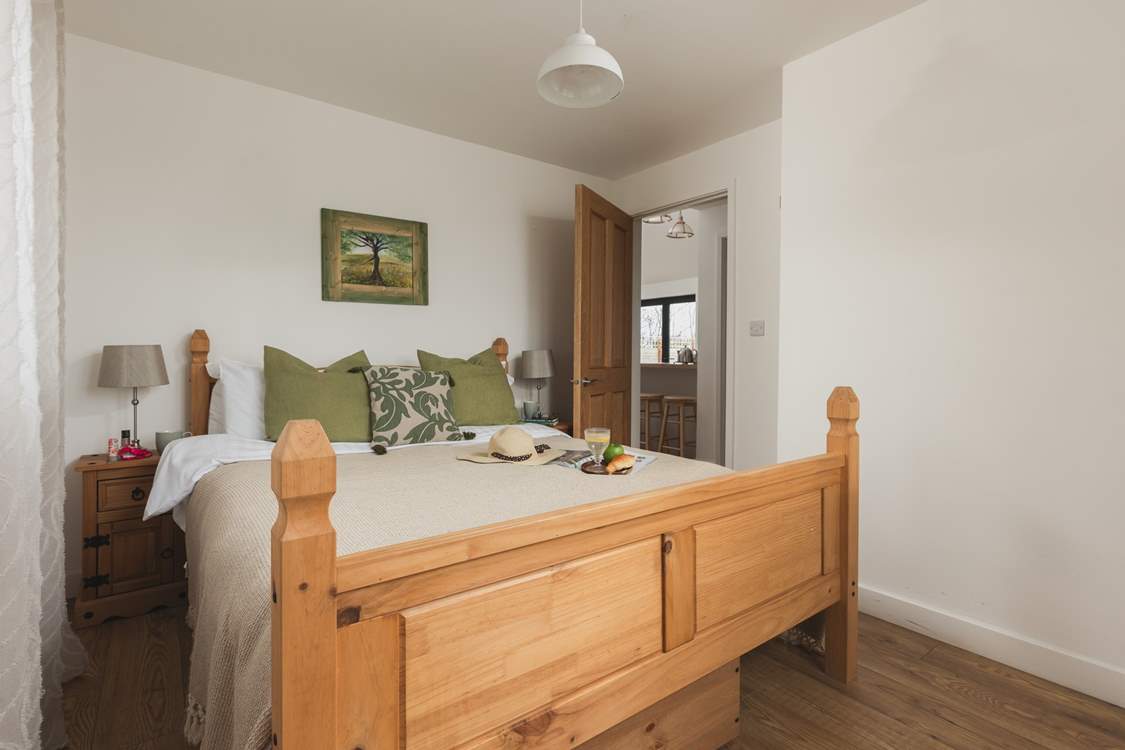 This bedroom is dual aspect with a king-size bed and TV.