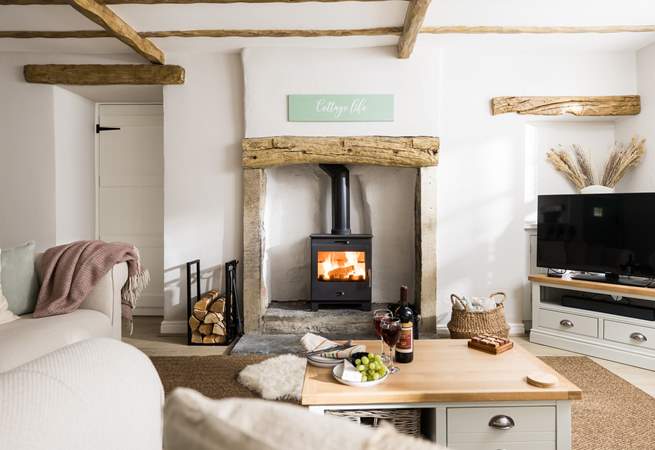 Relax in front of the wood-burner in this beautifully furnished sitting-room.