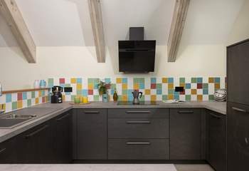 The kitchen overlooks the living area and is open airy and social.