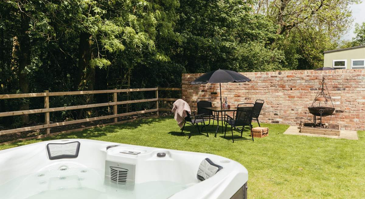 This charming private garden is is surrounded by woodland and has its own hot tub and fire-pit barbecue.