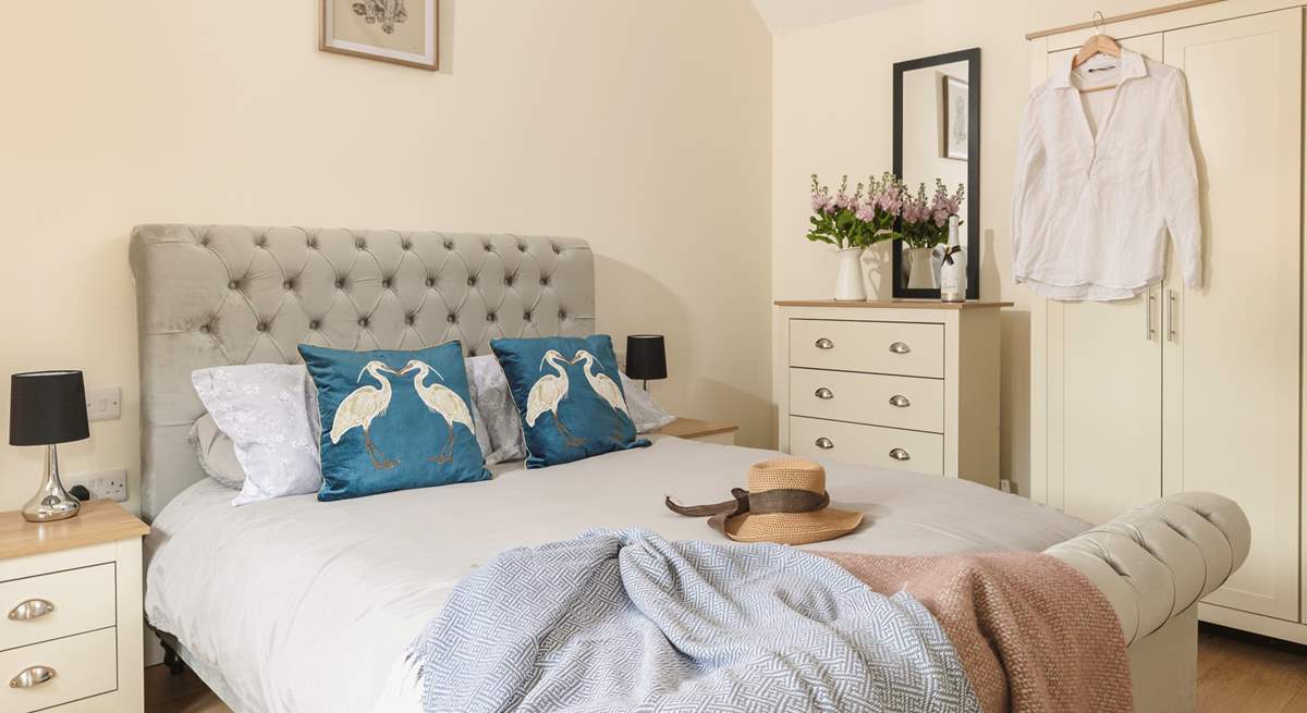 Quirky cushions adorn the bed in this cosy en suite double bedroom.  