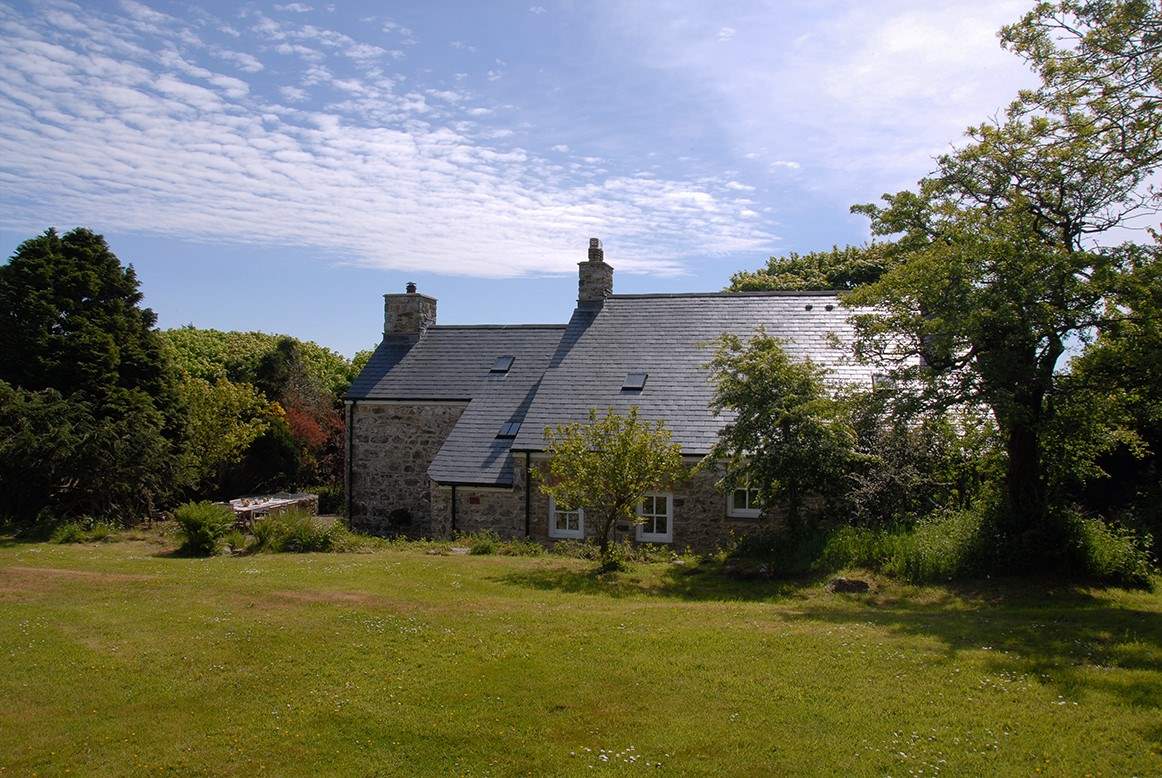 The idyllic farmhouse is surrounded by beautiful, mature gardens and large lawns.